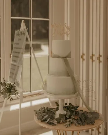 Single-tier white wedding cake with dried pampas grass and blush pink roses